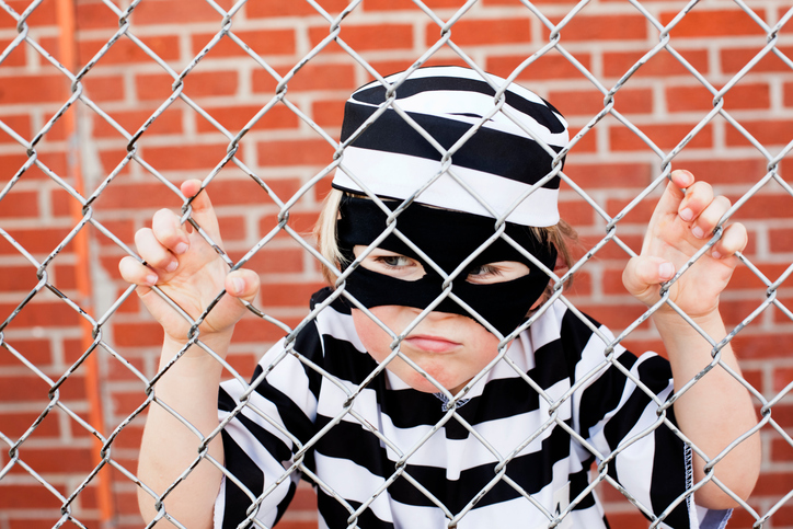 Child wearing inmate costume.